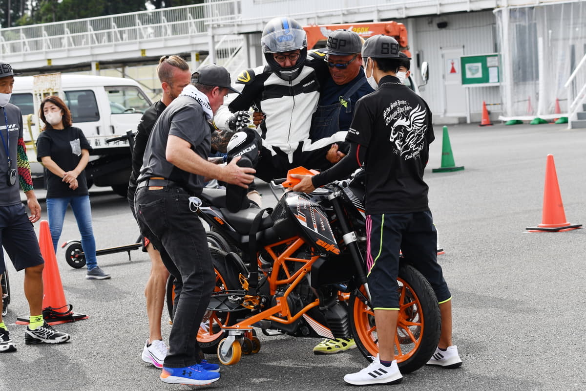 新たに後輪部分に補助輪を装着した車両を新作し、乗り込む様子