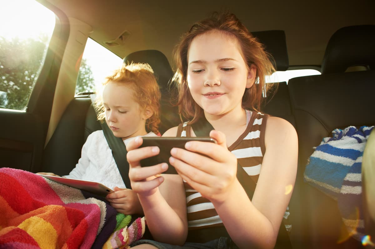 車内でスマホを見入る子どもたち