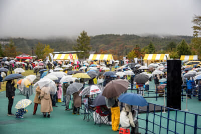 多くの参加者が雨のなかでもステージに熱視線を送っていた