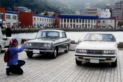 1966年式トヨタ「コロナ」と1979年式トヨタ「セリカ」の2ショット。海や雰囲気ある建物が背景にあるため、クルマを知らなくても写真を撮りたくなる好スポットだ