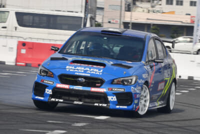 スバルWRX STI（左ハンドル仕様）、ドライバーズシートに見えるのは赤いヘルメットをかぶったモリゾー選手。モリゾー選手の走り出しを見て「大丈夫だ」とアライモータースのスタッフも太鼓判を押す