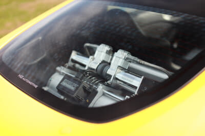 リアフードから見えるエアサスペンションシステム。基本はエアリフト製だが、エアタンクをビレットで作られたユニバーサルエア、サスペンションは地元福岡の老舗メーカーであるクルーズを装着