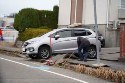 路肩を乗り越えようとして亀の子状態になった車両