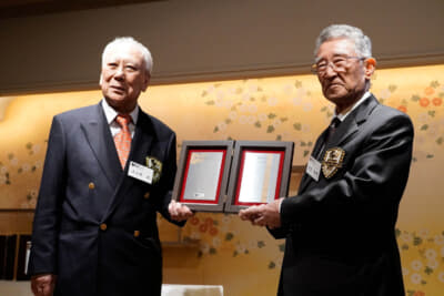 大久保 力会長より盾を手渡される多賀弘明さん。JAFスポーツ委員会やトヨタモータースポーツクラブの設立などモータースポーツを牽引