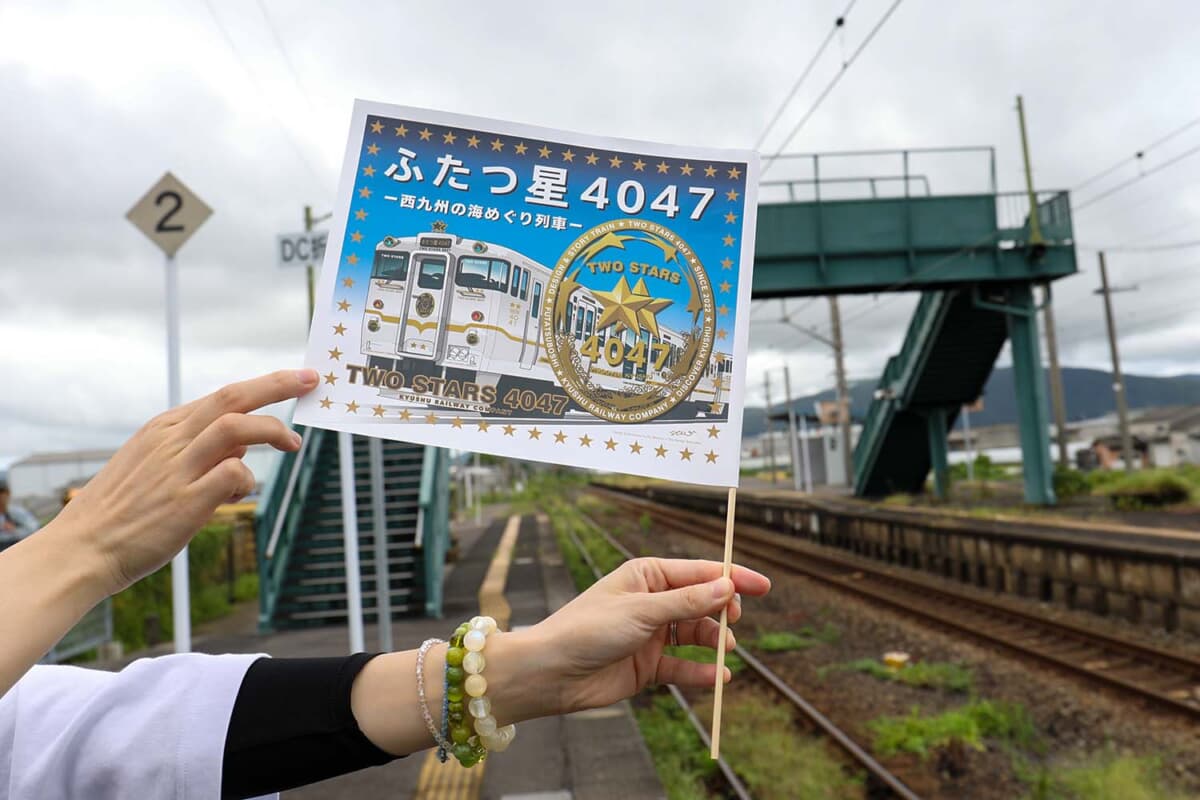 ふたつ星4047を歓迎するフラッグも配布。この列車は、D&S（デザイン＆ストーリー）列車と呼ばれ、JR九州が運行する観光列車。デザインと物語がある列車をコンセプトにしている