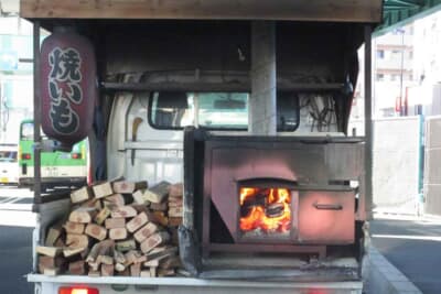 街で見かける石焼き芋屋は、薪がクルマの動力源ではないので問題なし