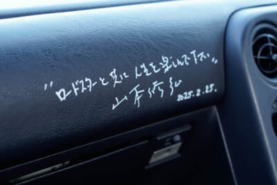 ユーノス ロードスター:ブック&カフェ「読×舎」に隣接した「みんなのコーヒー」はNAロードスターの吸排気系の開発責任者、横倉恒利さんのお気に入りということもあり、ND開発責任者の山本修弘さんと来訪した際に書いてもらったサイン。1年先の西暦はご愛嬌と言ったところ