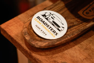 何気なく厨房に置かれていたのは、現役をリタイアして故郷である新居浜市に戻ってきた元マツダ、NAロードスター吸排気系の開発責任者、横倉恒利さんのチームバッジだ