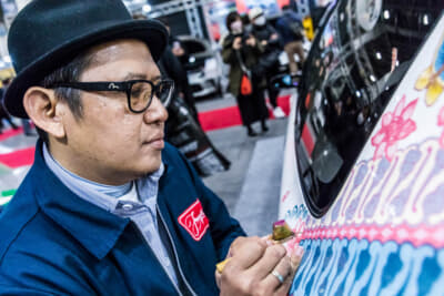 バティックの布を染める特殊な道具を使って車体にペイントする様はまさに匠の伝統技術