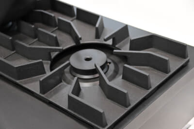 水素100％燃焼コンロ：五徳部分はトヨタが製造を担った鋳鉄五徳となっている。五徳の足は燃焼炎の部分にかかるわけだが、水素と酸素だけの燃焼のため、通常の五徳と異なる形状が採れるとしている