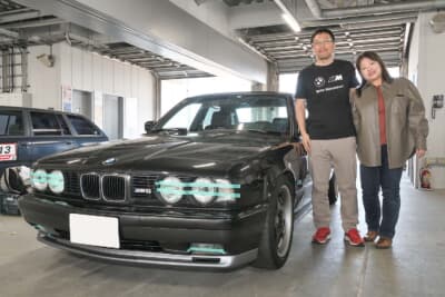 1994年式BMW E34M5と、オーナーの間々田祐二郎さんと奥様の優美さん