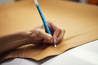 印の付けられた皮革は裁断機にかけられ、インテリア製造に必要な各パーツの輪郭がレーザーで素材に投影され、正確に裁断される