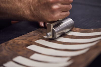 ロイヤルウォールナットのように木目がまっすぐな木材は、正確に55度の角度でシェブロンパターンに合わせて配置される