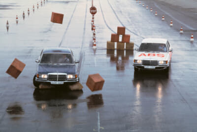 ABS（アンチロック・ブレーキング・システム）が世界に先駆けて1978年Sクラス／W116にオプション設定で4輪に搭載。写真は濡れた路面でのABSアンチロックブレーキシステム装着車（右）と非装着車の比較テスト