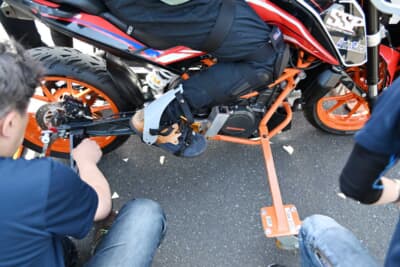 バイクは各参加者に合わせて仕様変更する。またSSPでは接地する角度に違いを設けたアウトリガーを複数用意しており、バイクの操作のレベルに応じてこれを付け替えながら走行を重ねていく