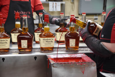 トレードマークの赤い蝋封は、担当者ふたりがおしゃべりをしながら作業していた