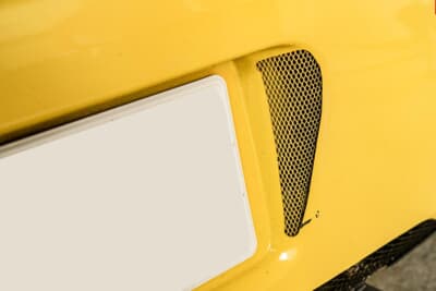 ダイハツ エッセ：リアのナンバープレート横にさり気なく開けたダクト。ネットはボディと同色に塗装する