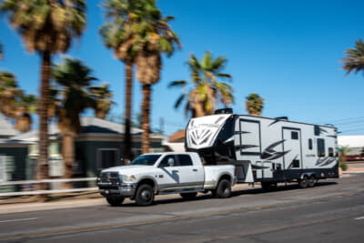 パワフルなピックアップで大きなキャンピングトレーラーを牽引する、いかにもアメリカらしい風景