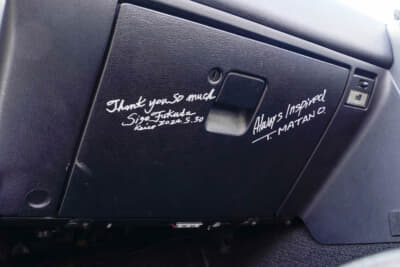 ユーノス ロードスター：グローブボックスのサインは、NAロードスターのデザイナー俣野 努氏と、元マツダのデザイナー福田成徳氏のもの。「ROKKO FESTIVAL 1991」の運営で知り合って以来、家族ぐるみのお付き合いという前田さん。ユーザーと距離の近いマツダの社風も、ロードスター愛をさらに深める