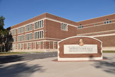 ボブ・ディランがノーベル文学賞を受賞したときの記念碑が高校の前に立つ。肖像はなぜかディランではなく、ノーベル