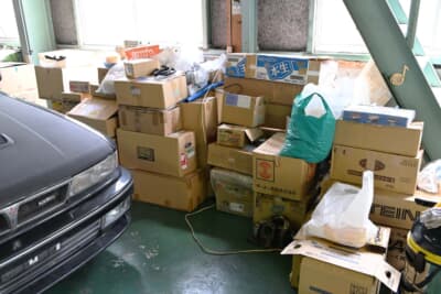 倉庫の片隅にある段ボールの山はストックパーツ。オークションサイトなどで見つけては購入を重ねてきた結果がこれだ（そのすべてということではない）