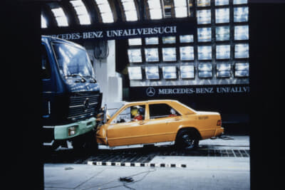 コンパティビリティの哲学を世界で初めて市販車に本格的に導入したのが、1995年に発表したEクラス／W210。つまり、自らの衝撃吸収能力をより高めることで生まれたクラッシャブルゾーンの余裕を相手方の車両と分かち合うということ。写真はEクラス／W201と大型トラックとの衝突テスト