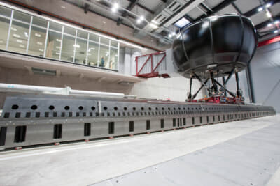 このムービングベースシミュレーターは360度スクリーン、高速電気システム、テストセットアップに応じて横方向または縦方向の動きに対応する12mの長さのレールを備え、シミュレーターセルは6つの可動支柱に取り付けられている