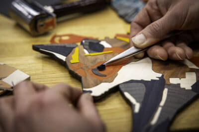 キツネが静かに森へ足を踏み入れる様子が、精緻な寄木細工により描かれている