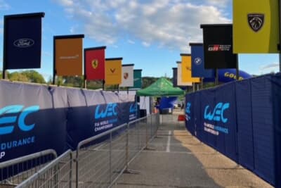 WEC(FIA世界耐久選⼿権)のファンエリアからの出入り口。さまざまなメーカーの旗が飾られています