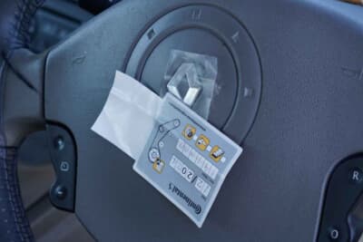 ルノー カングー：ステアリングホイールのセンターにあったのは、タイミングベルト交換のシール。先日、19万キロで交換したばかりで、エンジンルームに貼ってくださいと整備工場ブラストオフから渡されたまま