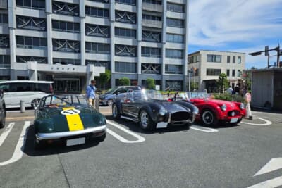 一般駐車場に置かれていたロータス初代エラン(左)、ACコブラ レプリカ(中)、トライアンフTR3(右)