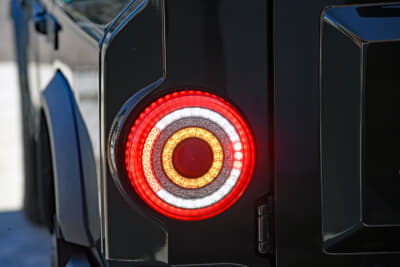 イネオス「グレナディア」：外側よりテール灯兼ブレーキ灯。一つ内側に白色のバックライトと、赤色のバックフォグライトを同一周に配置。一つ飛んでオレンジのウィンカー。中心に反射板がレイアウトされている