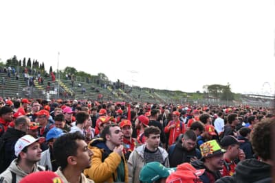 グランドスタンドからコース上に表彰式を見ようと集まったファン