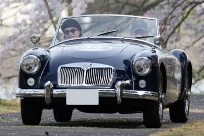 アートビレッジ明神池の周回路を使ってのPC競技をする参加車両たち、今回は桜がピークということもあり希少なヒストリックカーと桜の写真を収めようという見学客も多いポイントであった