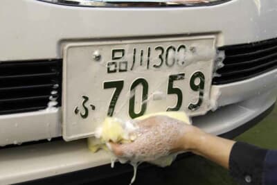 カーシャンプーを使用し、ナンバープレートの汚れを落とす