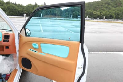 スズキ HA23型 アルト：スカイブルーのフィルムをウインドウに貼っている