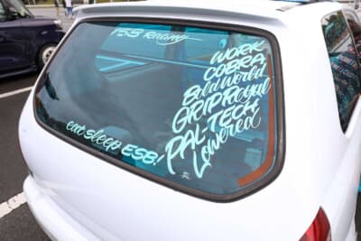 スズキ HA23型 アルト：スカイブルーのフィルムをウインドウに貼っている