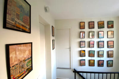 バーバラさんの素敵なお家の2階の階段を上がったところ。訪れた街の絵が飾られています