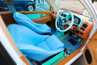 スズキ HA23型 アルト：ポップなオレンジ色のアルカンターラ生地を貼ったパネルに加えて、ホイールと同色のスカイブルーカラーをフロア、コブラバケットシート、ディープコーンステアリングにコーディネートしている