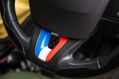 ルノー カングー：シルバーで味気ない純正ステアリングのスポーク部。それは商用車ベースゆえのもので、日本のオーナーにしてみるとカングーは、それだと楽しめないのでトリコロールにDIYで加飾されている