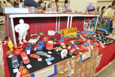 OT オートモーティブ サービス：1950〜1960年代のビンテージ・ミニカー、モーター系キーホルダーやピンバッジなど、ブースの雰囲気はまるでパリのレトロモービルのよう