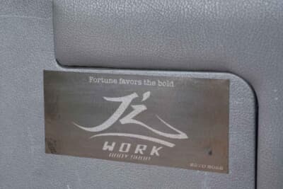 トヨタ ハイエース：みんなのコーヒーと同じ新居浜市にある自動車修理工場“ジェイズワークス”がオールペイントを施したという証であるプラークが荷室にあった