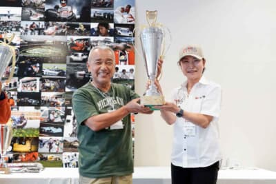  Gen.1での優勝はシェブロンB19（コスワースBDG）の兼子選手。GCリターンズを応援する株式会社永光の神田尚子社長からカップが手渡された