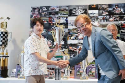 Gen.2で関谷正徳選手に続き2位でフィニッシュしたMCS マツダの上住道人選手に、GCリターンズを応援するオークランド観光開発株式会社の松永副社長からカップが手渡された
