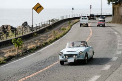 ダットサン1500 スポーツロードスター：太平洋を臨む海岸線を気持ちよさそうに走る、一色さん親子ペアの1964年式ダットサン1500 スポーツロードスター（SPL310）