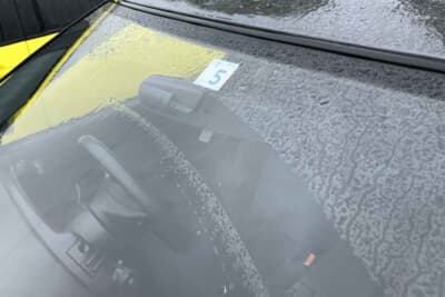 従来は車検ステッカーの貼付位置はフロントウインドウの中央または運転席の反対側だったが、現在は運転席側の端に貼付する