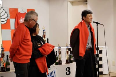 ランチア フルビア スポルト ザガート:ミルキーウェイのパーティーではその年に還暦を迎えたエントラントに記念の赤いトレーナーが贈られる恒例行事がある。2024年に還暦を迎えた桂さん、エントラントからのお祝いの祝福を受ける