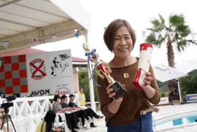 ランチア フルビア スポルト ザガート:これで最後となったミルキーウェイブルーアイランドラリー、表彰台は逃したもの5位に入賞という堂々たる成績に、恵里さんも悔いは無い!? 素敵な笑顔でポーズを取ってくれた