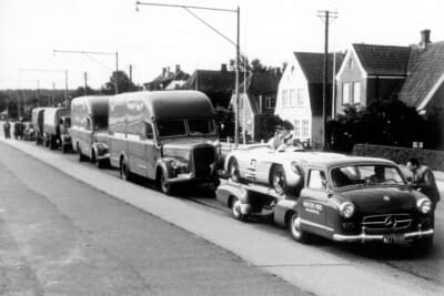 写真はブルーワンダーを先頭に1955年8月7日のスウェーデンGPに参戦するためにアペンラーデ（デンマーク）から移動するメルセデス・ベンツ大部隊。荷台には300SLR/W196S搭載。このスウェーデンGPでも300SLR/W196Sはエアブレーキ付きを使用