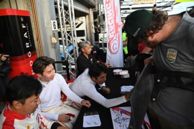 リアウィングを持ってきてサインを望むファン